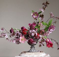 a vase filled with lots of flowers on top of a table