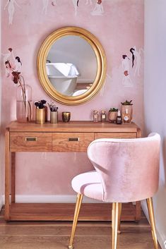 a vanity with a mirror and pink chair