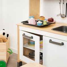 a small child's play kitchen with toys in it