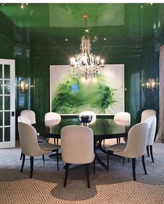 a dining room with green walls and chandelier