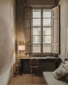 a room with a bed, desk and window