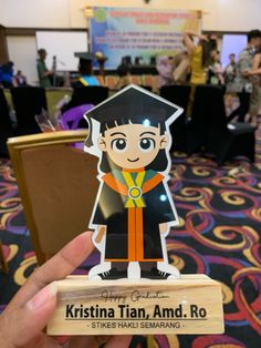 a person holding up a card with an image of a graduate on it