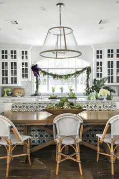 a dining room table with four chairs and a chandelier hanging from the ceiling