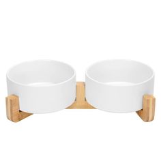 two white bowls on wooden stand against a white background