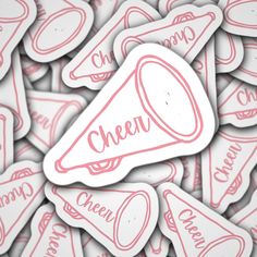 a pile of pink and white stickers with the word cheer on them in red ink