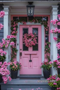 a pink door surrounded by potted flowers and hanging planters on the front porch