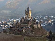 an old castle sits on top of a hill