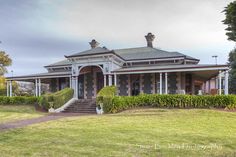 an old style house in the middle of a grassy area