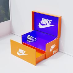 an orange and blue nike shoe box sitting on top of a white floor next to a window