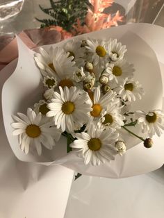 a bouquet of daisies in a white bowl