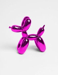 a pink balloon dog sitting on top of a white table