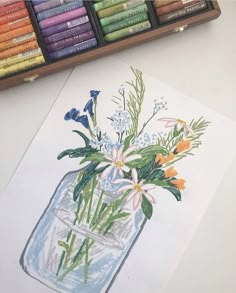 a drawing of flowers in a mason jar with colored crayons next to it