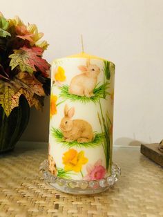 a candle that is sitting on a table next to a potted plant and some flowers