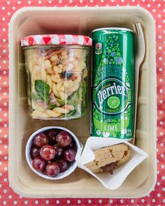 a lunch box with fruit, crackers and soda