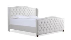 a white bed with an upholstered headboard and foot board