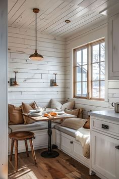 a kitchen with white walls and wood flooring on the ceiling, along with a breakfast nook