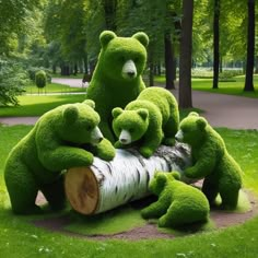 four green teddy bears sitting on top of a tree log in the middle of a park