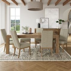 a dining room table with chairs and a rug on the floor