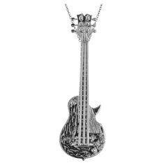 an intricately designed guitar necklace with a skull on it's neck, hanging from a chain