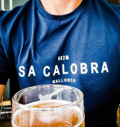 a man in a blue shirt is holding a beer