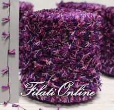 two purple crocheted hats sitting next to each other