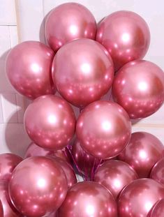 a bunch of shiny pink balloons sitting on top of each other