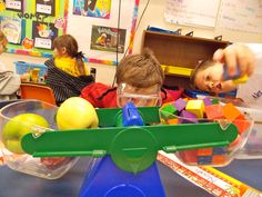 two children are playing with toys in a classroom