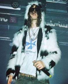 a man with long hair wearing a fur coat