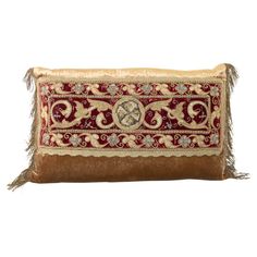 a brown and red pillow with fringes on the bottom, in front of a white background