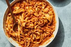 a bowl filled with pasta and sauce on top of a table