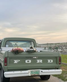 the truck is parked on the side of the road by the water and dock area