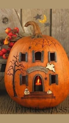 a carved pumpkin with an image of a house on the front and windows in the back