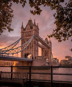 the tower bridge is lit up at sunset