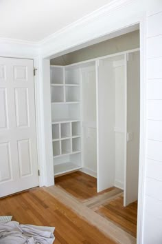 an empty room with white closets and wood floors