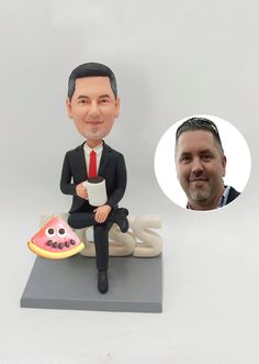 a bobble head sitting on top of a table next to a figurine