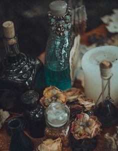 an assortment of glass bottles and candles on a table