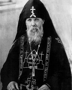 an old black and white photo of a man with a long beard wearing a priest's outfit