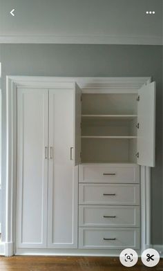 an empty closet with white drawers and doors