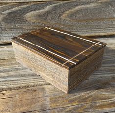 a small wooden box sitting on top of a wooden table next to wood planks