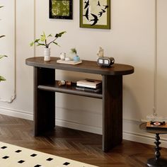 a wooden table sitting in the middle of a living room next to a wall with pictures on it