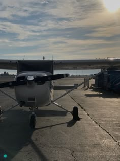 an airplane is parked on the tarmac at sunset