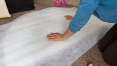 a woman kneeling down on top of a white rug