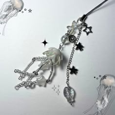 an image of a necklace with jellyfishs and stars hanging from it's sides