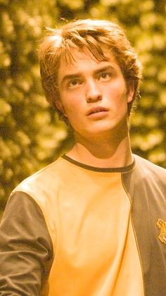 a young man holding a frisbee in his right hand and looking at the camera