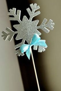 there is a cake topper that has snowflakes on it with blue bows