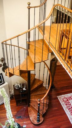 a spiral staircase with wooden handrails in a home