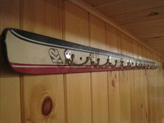 a row of skis mounted to the side of a wooden wall with hooks on it