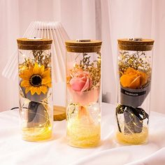 three vases with flowers in them sitting on a table