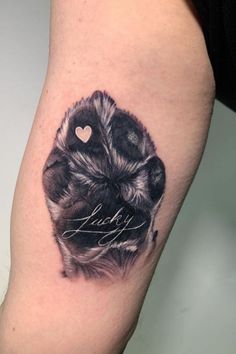 a black and white photo of a dog's paw with the word love written on it