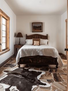 a large bed in a bedroom next to two windows